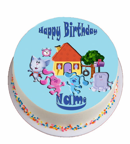 Round  blue clue birthday cake topper with cartoon characters on a beach, featuring 'Happy Birthday' text.