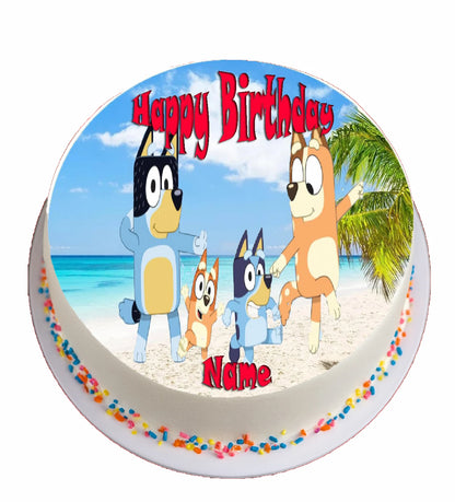 Round birthday edible image cake topper with bluey cartoon characters on a beach, featuring 'Happy Birthday' text.
