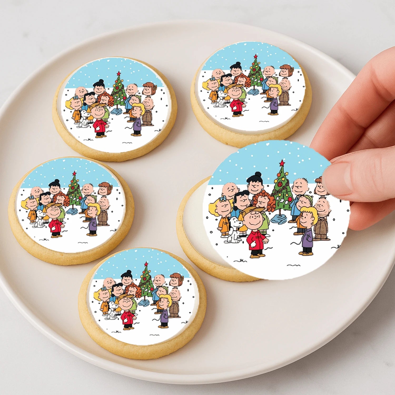 Cookies with Charlie Brown and friends illustrations on a white plate.