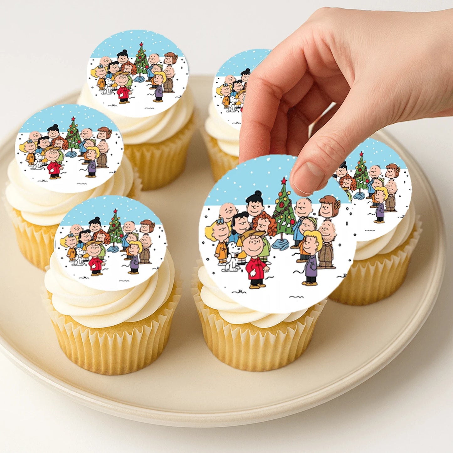 Applying Christmas Charlie Brown edible cake images on frosted cupcake – Christmas Charlie Brown edible cake images are perfect holiday treats