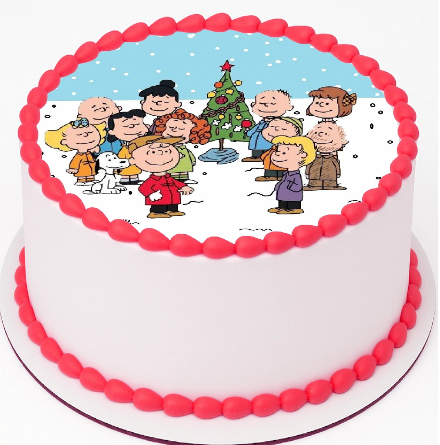 Edible Cake Image of a fun Classic Charlie Brown Christmas gathered around christmas tree on top a cake with red frosting trimming.