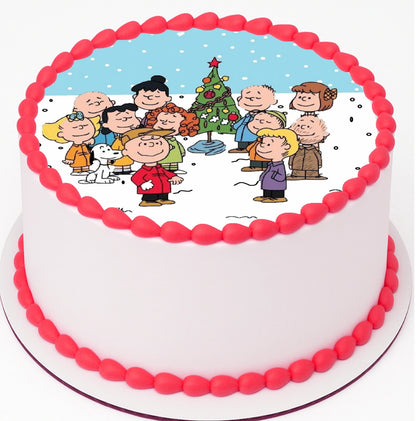 Edible Cake Image of a fun Classic Charlie Brown Christmas gathered around christmas tree on top a cake with red frosting trimming.