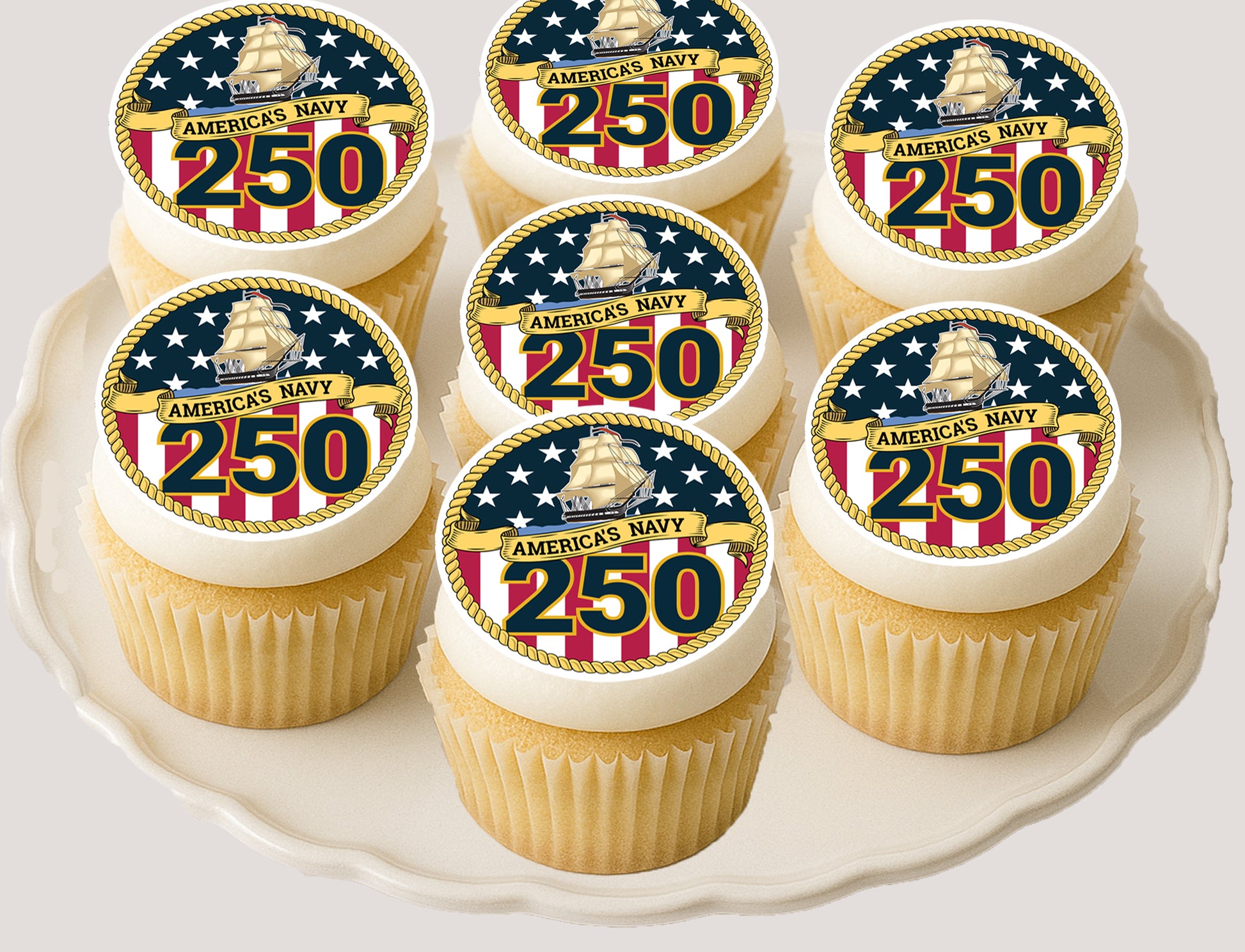 Cupcakes with America's Navy 250th anniversary edible image  toppers on a white plate.