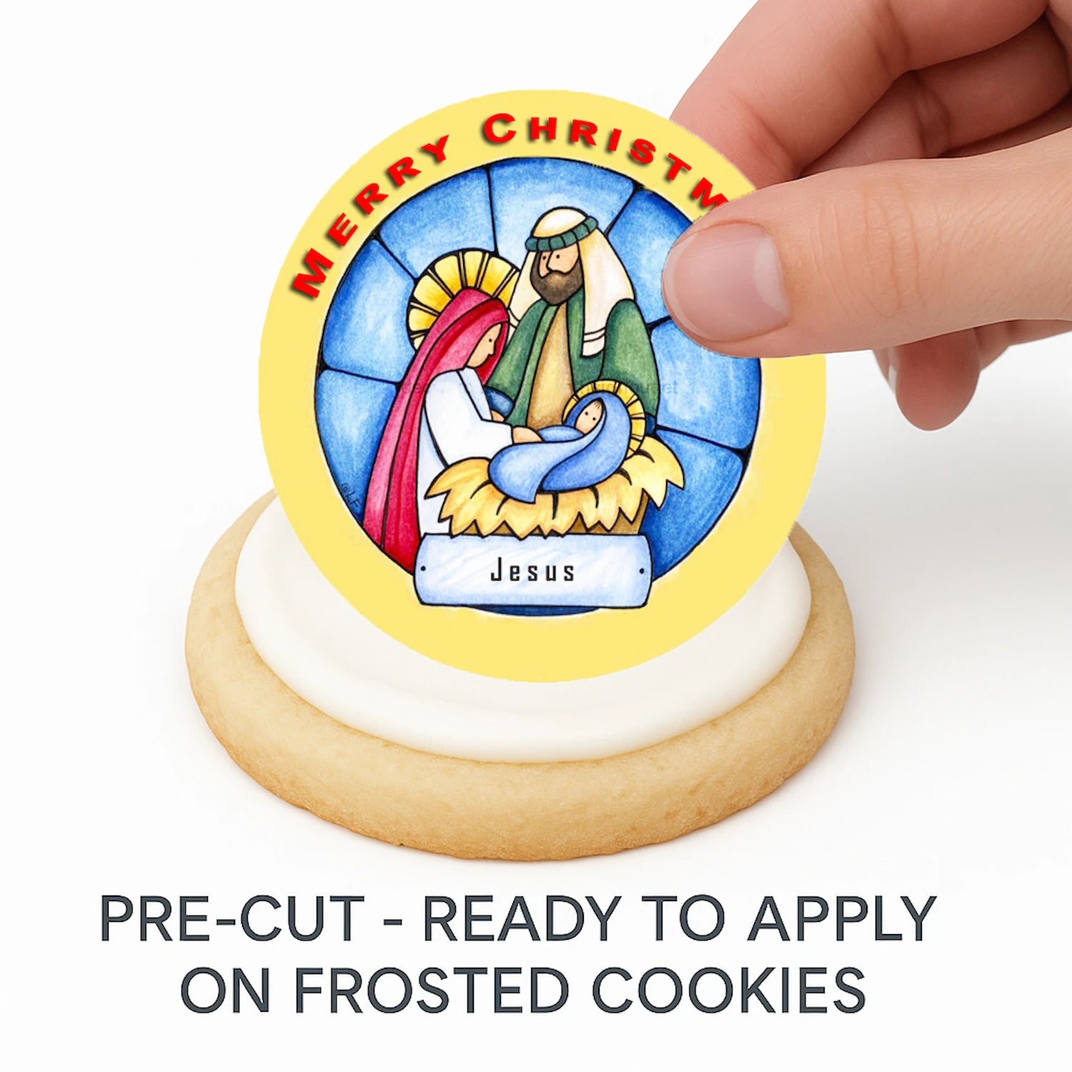 Hand placing pre-cut Christmas Nativity edible cake image on frosted cookie –  holiday cookie icing sheet