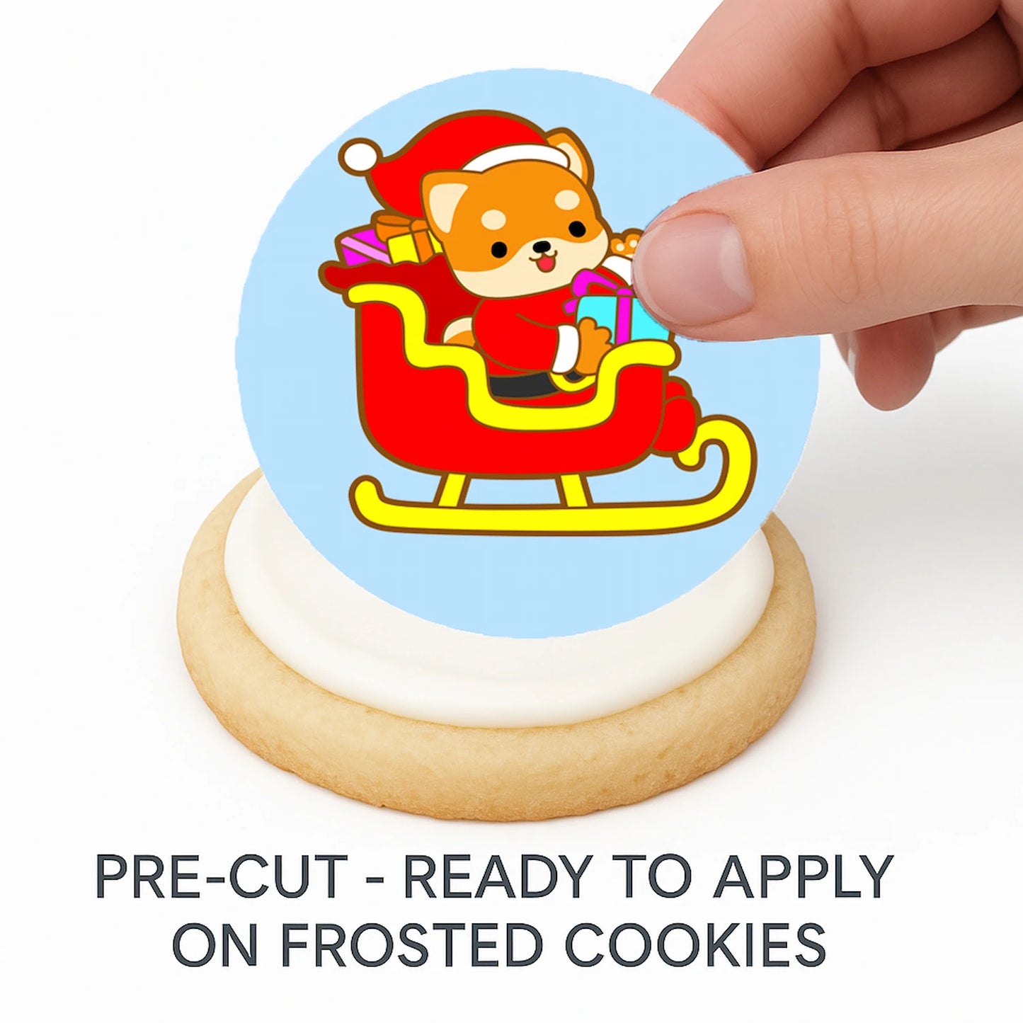 Hand placing pre-cut Christmas Sleigh-Ride Sweeties edible cake image on frosted cookie –  holiday cookie icing sheet