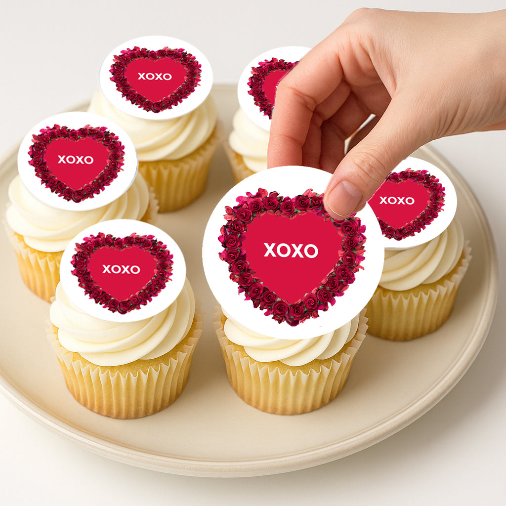 Cupcakes with heart-shaped XOXO toppers on a plate
