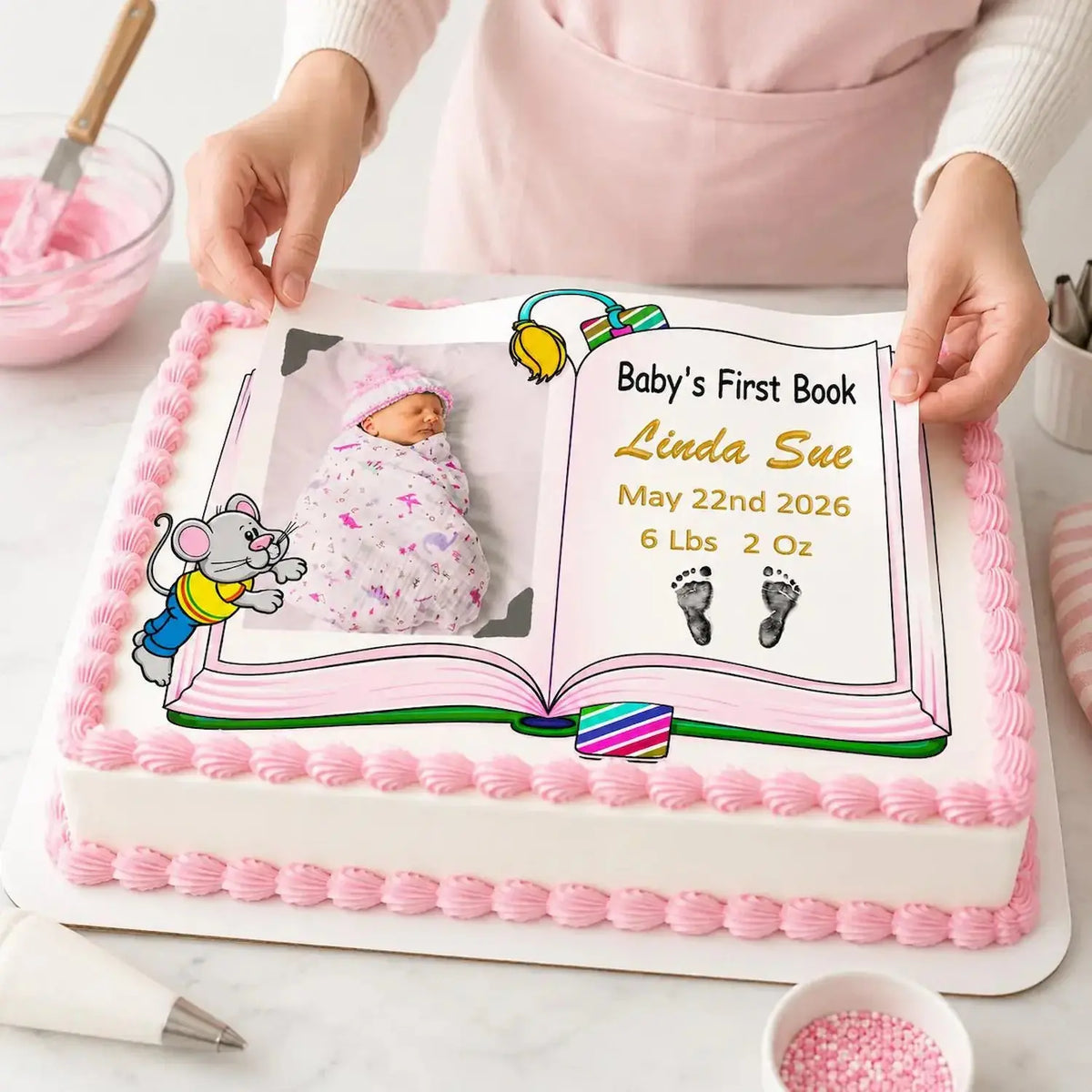 Easy to Apply: placing an 8.5 x 10.5-inch edible icing sheet featuring Baby's First Book design with a girl photo and birth details onto a frosted cake