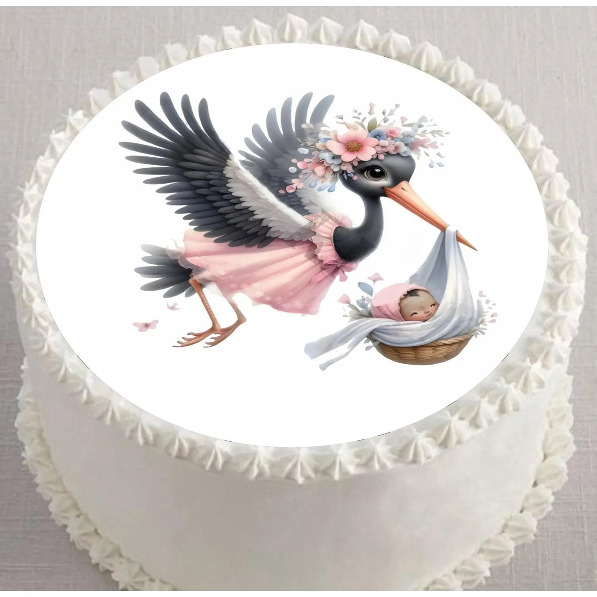 Precut 8-inch round edible icing topper featuring black-and-white stork carrying a baby girl displayed on a frosted cake
