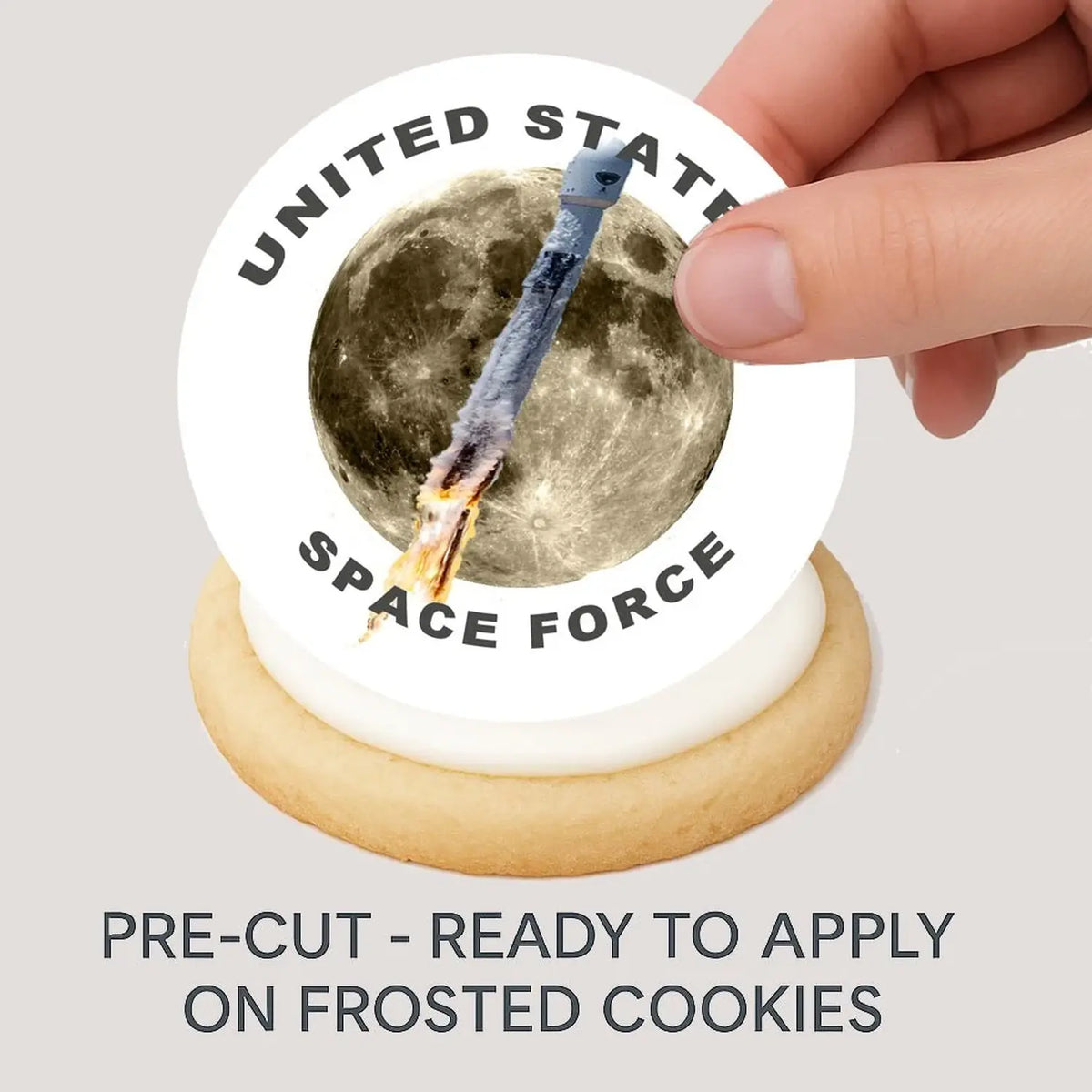 Space Force Rocket to the Moon Edible Cookie & Cupcake Toppers – 20 Precut being placed on a frosted cookie.