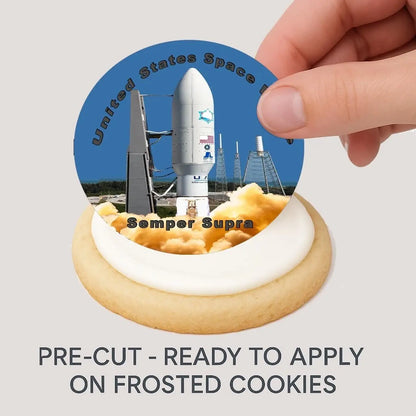 Space Force Semper Supra Edible Cookie & Cupcake Toppers – 20 Precut being placed on a frosted cookie.
